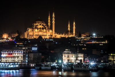 Low angle view of illuminated suleymaniye mosque and cityscape at night