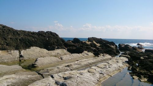 Rocks on beach against sky