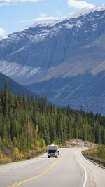 Car on road by mountain against sky