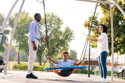 Full length of boy swinging at playground