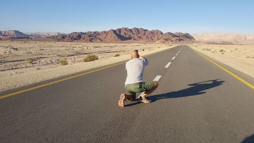 Rear view of woman walking on road