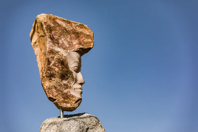 Low angle view of statue against blue sky