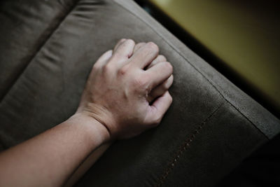 Close-up of hands on sofa