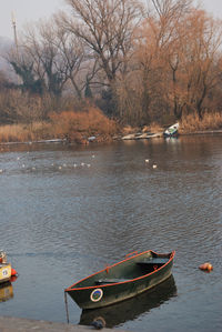 Boat moored in lake against sky