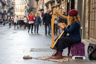 Woman sitting on street in city