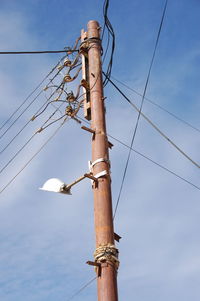 Low angle view of electricity pylon against sky