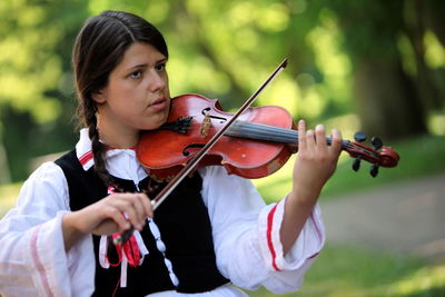 Woman playing guitar in park