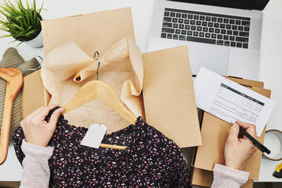 Business owner packing online order to delivery to customer. preparing parcel box with clothes