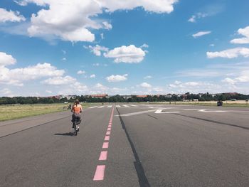 Woman cycling on tempelhofer feld in berlin