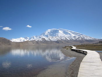 Scenic view of winding dock in lake with mountains in background