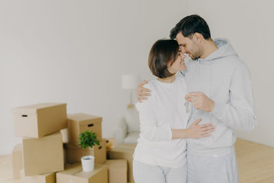 Couple embracing while standing at new home