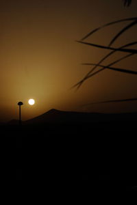 Silhouette tree against orange sky