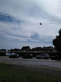 Cars on street in city against sky