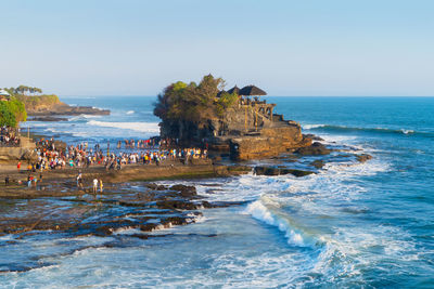 Group of people on beach against clear sky