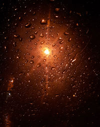 Low angle view of raindrops on glass