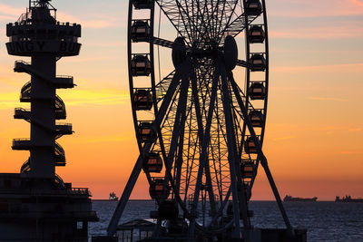 Silhouette ferris wheel against sky during sunset