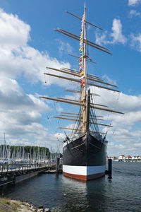 Sailboat moored on sea against sky