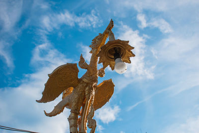 Low angle view of sculpture against blue sky