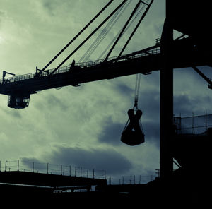 Low angle view of crane against sky