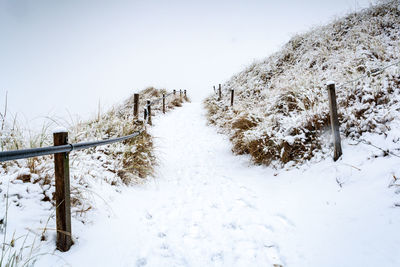 Scenic view of snow covered field against sky