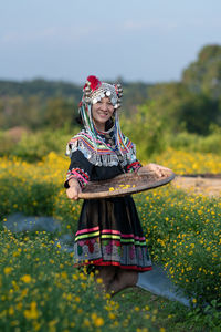 Woman with umbrella standing on field