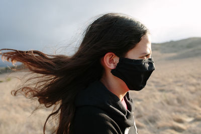 Portrait of beautiful woman on land against sky