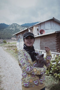 Portrait of woman with cat standing outdoors 