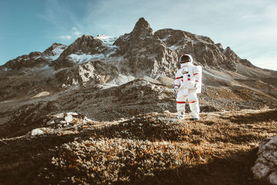 Full length of man standing on rock against sky