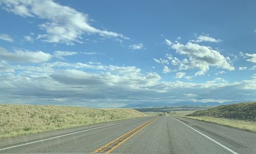 View of country road against cloudy sky