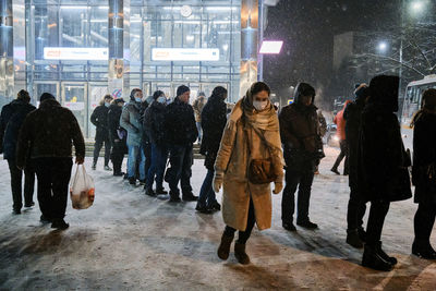 Group of people walking on road in city at night