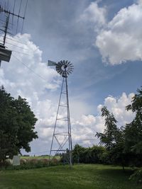 Low angle view of windmill on field against sky