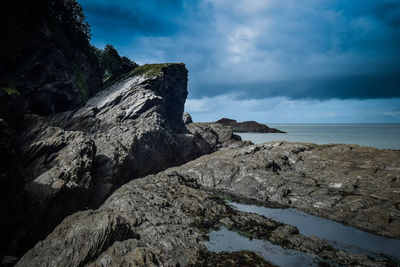 Rock formation in sea against sky