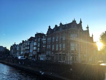 Building by river against clear sky