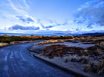 Empty road against cloudy sky