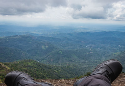 Low section of man on landscape against sky