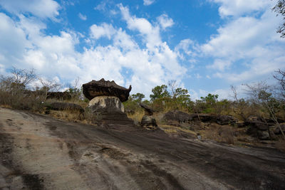 Built structure on landscape against cloudy sky