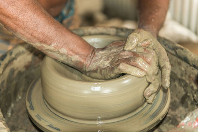Cropped image of hands making pottery