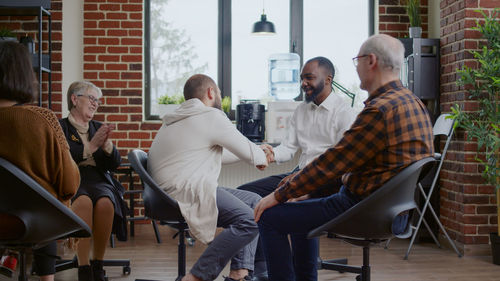 People shaking hands while sitting for psychotherapy