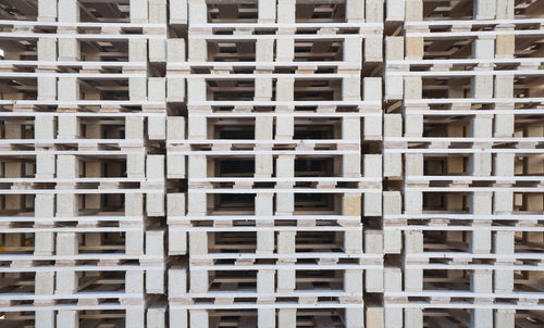 A wall of wood pallets stacked one above the other