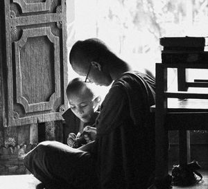 Side view of mother and daughter sitting on floor