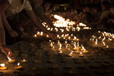 High angle view of hands lighting candles on land