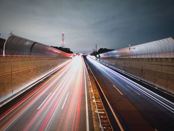 Light trails on highway against sky in city