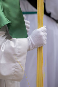 Close-up of person holding yellow while standing outdoors