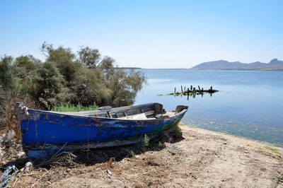 Boats moored on sea against clear sky