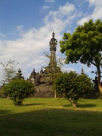 View of temple on field against cloudy sky