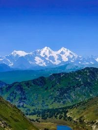 Scenic view of snowcapped mountains against clear blue sky