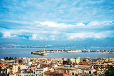 High angle view of cityscape by sea against sky