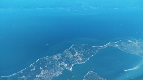 Aerial view of frozen sea against blue sky