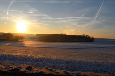 Scenic view of frozen lake against sky during sunset