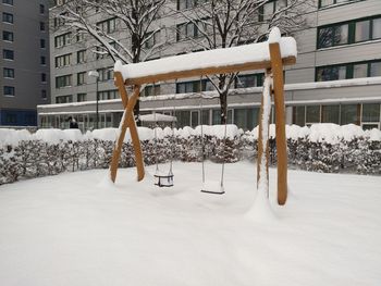 Snow covered bare tree in city